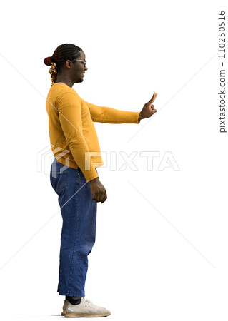 A man in a yellow sweater on a White background shows a victory sign, in profile A man in a yellow sweater on a White background shows a victory sign, in profile 110250516