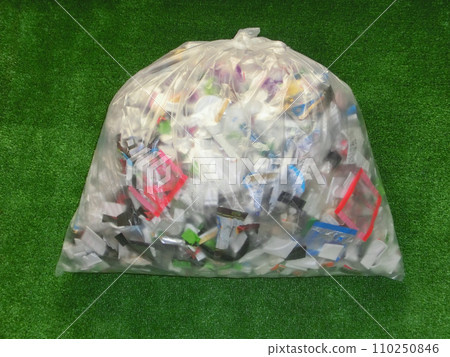 A plastic bag containing recyclable plastic waste placed on artificial grass 110250846