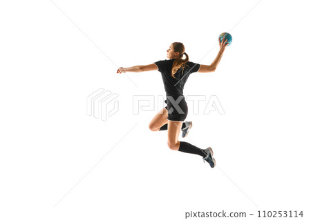 Fit young woman engaged in intense handball training, perfecting her throwing and catching abilities against white studio background. Concept of sport. 110253114