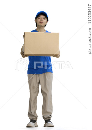 The delivery guy, on a white background, in full height, gives a box The delivery guy, on a white background, in full height, gives a box 110253427