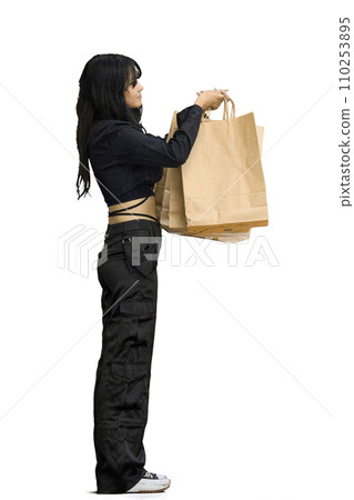 A woman in black clothes, on a white background, full-length, with bags A woman in black clothes, on a white background, full-length, with bags 110253895