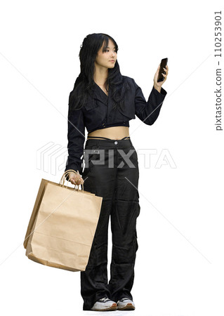 A woman in black clothes, on a white background, full-length, with bags and a phone 110253901