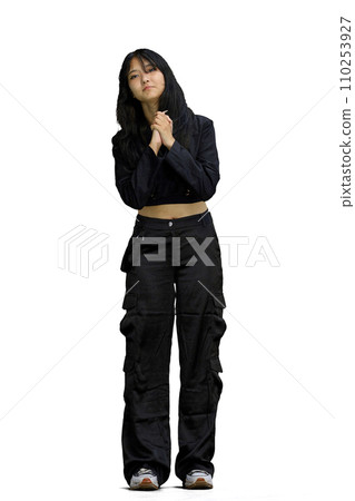 A woman in black clothes, on a white background, in full height, is touched A woman in black clothes, on a white background, in full height, is touched 110253927