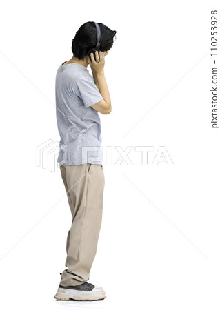 A guy in a gray T-shirt, on a white background, full-length, wearing headphones 110253928