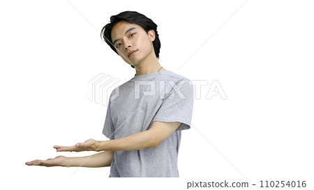 A guy in a gray T-shirt, on a white background, close-up, pointing side 110254016