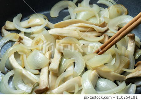 Stir-fried onions and king mushrooms, cooking scene. 110254191