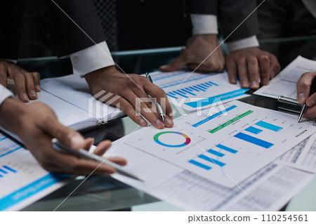 business colleagues look at the graph on the table from above business colleagues look at the graph on the table from above 110254561