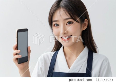 一位穿著圍裙的美麗家庭主婦在操作智慧型手機時微笑 110254973