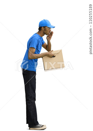 A male deliveryman, on a white background, full-length, with a box, tells a secret A male deliveryman, on a white background, full-length, with a box, tells a secret 110255189