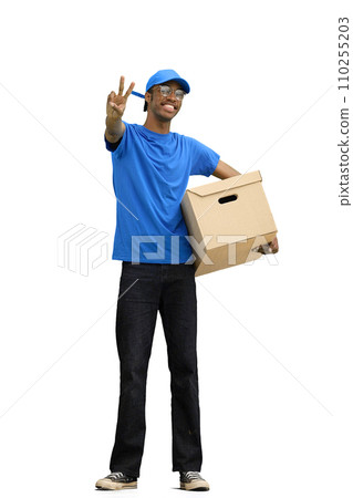 A male deliveryman, on a white background, in full height, with a box, shows a victory sign A male deliveryman, on a white background, in full height, with a box, shows a victory sign 110255203