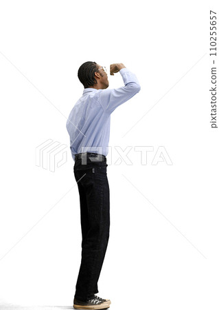 A man in a gray shirt, on a white background, in full height, rejoices 110255657