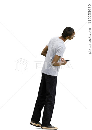 A man in a gray T-shirt, on a white background, full-length, with a phone 110255680