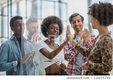 Successful business people giving each other a high five in a meeting 110255748