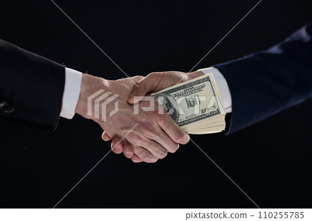 Handshake with the transfer of money on a black background 110255785