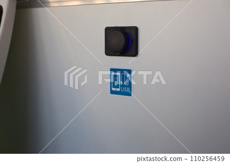 Connector for USB charging on the wall in public transport. Phone charging icon in a city bus 110256459