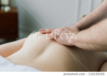 Young fat woman getting massage treatment in day spa cabinet. Young fat woman getting massage treatment in day spa cabinet. 110256500