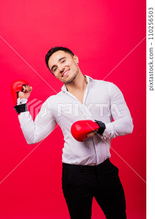 Businessman standing with boxing gloves over red background. Looking at camera 110256503