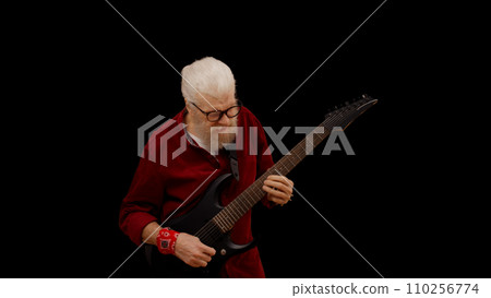 Contemporary senior man plays the electric guitar against a black background, showcasing his rockstar persona Contemporary senior man plays the electric guitar against a black background, showcasing his rockstar persona 110256774