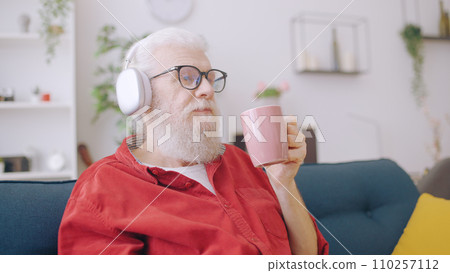 Senior man listens to music and enjoys his morning coffee, a time for relaxation and leisure 110257112
