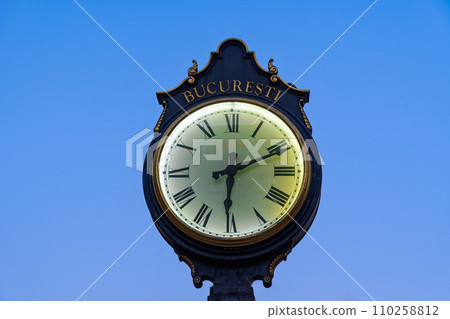 A traditional big public clock in Romania displaying the time with the word Bucuresti in Romanian and the 1459 year inscription under a clear sky in the evening. A traditional big public clock in Romania displaying the time with the word Bucuresti in Romanian and the 1459 year inscription under a clear sky in the evening. 110258812