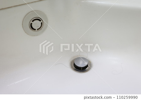 浴室排水管周圍的區域很髒，有頭髮和水垢。 110259990