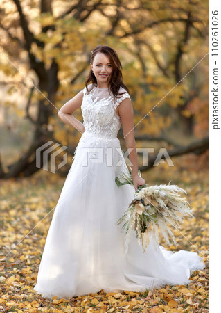 beautiful happy bride holding wedding autumn bouquet in nature 110261026