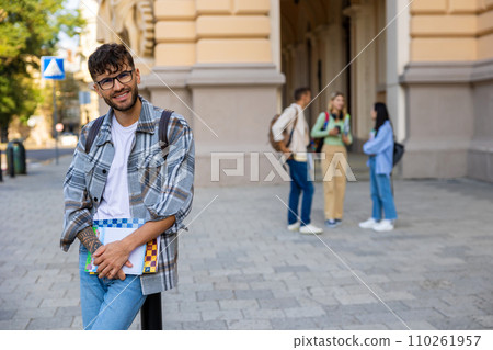Smiling young guy in checkered shirt looking contented Smiling young guy in checkered shirt looking contented 110261957