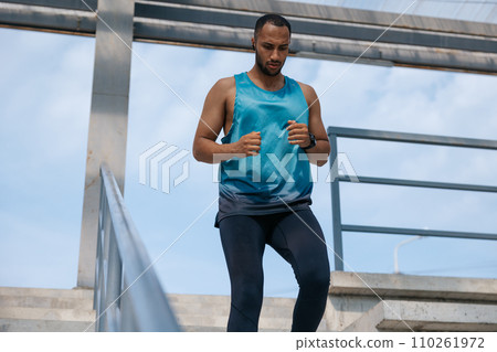 Man in blue tshirt running and looking concentrated Man in blue tshirt running and looking concentrated 110261972