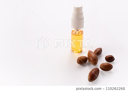 Hairloss concept. Argan seeds, oil and hair isolated on a white background 110262268