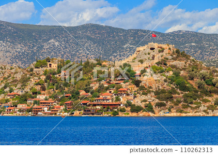View of ancient Lycian town Simena with fortress on a mount on the coast of the Mediterranean sea in Antalya Province, Turkey 110262313