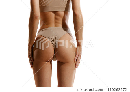 Cropped back view image of slim female body, buttocks in beige cotton underwear against white studio background. Anti-cellulite care, massage Cropped back view image of slim female body, buttocks in beige cotton underwear against white studio background. Anti-cellulite care, massage 110262372