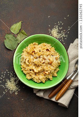 Ven Pongal (Khara Pongal), traditional Indian savoury rice dish made during celebrating Pongal festival, served in bowl top view on concrete rustic background Ven Pongal (Khara Pongal), traditional Indian savoury rice dish made during celebrating Pongal festival, served in bowl top view on concrete rustic background 110262745