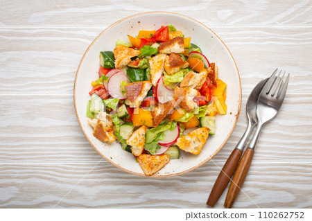 Traditional Levant dish Fattoush salad, Arab cuisine, with pita bread croutons, vegetables, herbs. Healthy Middle Eastern vegetarian salad, rustic wooden white background top view Traditional Levant dish Fattoush salad, Arab cuisine, with pita bread croutons, vegetables, herbs. Healthy Middle Eastern vegetarian salad, rustic wooden white background top view 110262752