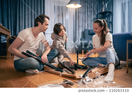 The family enthusiastically makes a chair bought at a furniture store. 110263310