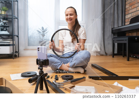 A girl shows furniture details via video link using the camera of her smartphone 110263337