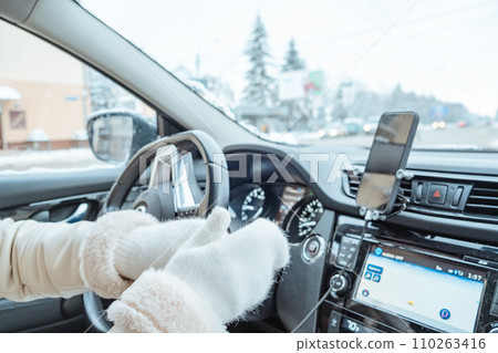 woman hands in winter gloves on steering wheel woman hands in winter gloves on steering wheel 110263416