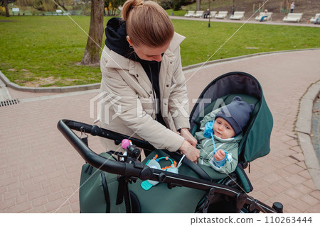 mother to fasten her son with seat belts mother to fasten her son with seat belts 110263444