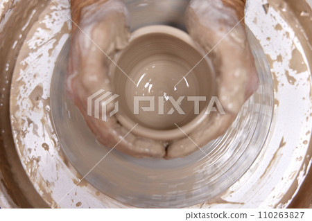 male hands making ceramic cup on pottery wheel, Close-up, top view 110263827