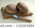 portobello mushrooms on wooden table. brown mushrooms, on a dark table with cutting board. Selective focus. 110263884
