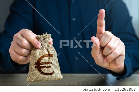 A man warns with his finger offering a euro money bag. Bad credit history. Funding and grants. Banks and finance. Terms of borrowing money. Strict conditions. Loan for a specific purpose. 110263898