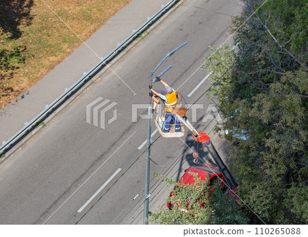 Workers installing a new street lamp. 110265088