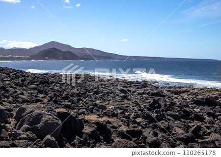Coast with lava stonesl and a mountain, Lanzarote, Spain 110265178