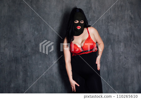 A masked woman in a dark room is a bandit A masked woman in a dark room is a bandit 110265610