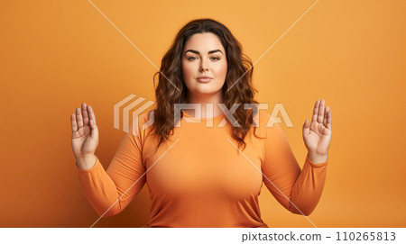 Portrait of a young woman meditating on a orange background.  110265813