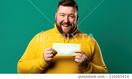 A man in a yellow sweater on a green background shows a blank white sheet. 110265814