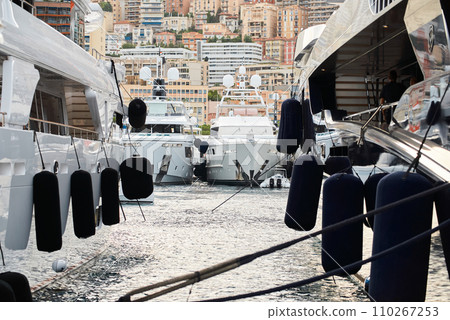 Sun glare on glossy board of mega yacht, anchor, tranquillity in port Hercules, bow of moored huge boat at sunny day, Monaco, Monte-Carlo 110267253