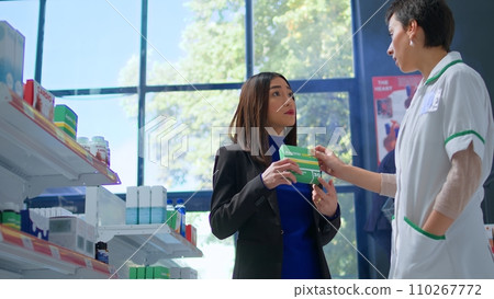 Asian client in modern apothecary asking experienced pharmacist for medical expertise. Licensed druggist helping customer trying to pick best pharmaceutical product to lower headache Asian client in modern apothecary asking experienced pharmacist for medical expertise. Licensed druggist helping customer trying to pick best pharmaceutical product to lower headache 110267772