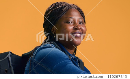 Healthy african american courier with food delivery bag is taking orders to customers. Eco-conscious black woman using bicycle for delivering packages on-time for customer satisfaction. 110267843