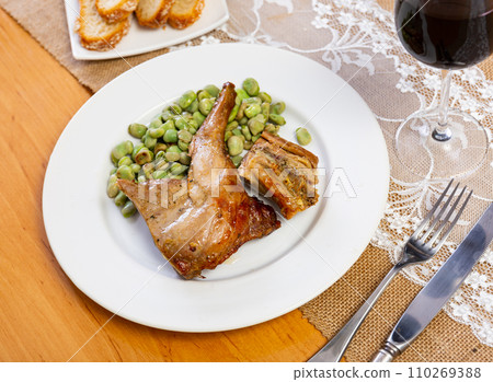 Oven-baked rabbit leg with braised beans in bowl, top view. Oven-baked rabbit leg with braised beans in bowl, top view. 110269388