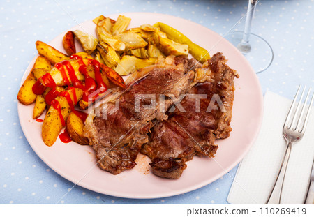 Veal steak with grilled potato and artichokes 110269419